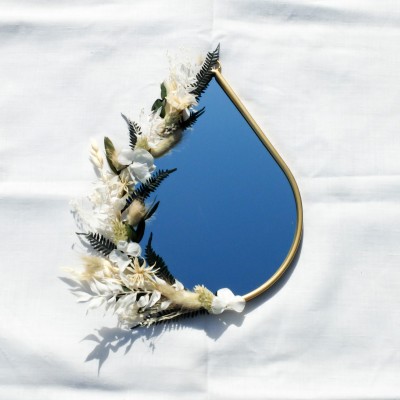 Miroir doré en forme de goutte décoré de fleurs séchées blanches, beige et vert foncé. Différents formats.