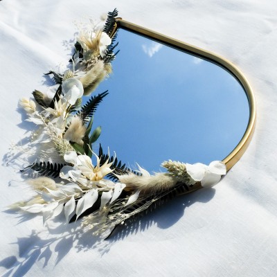 Miroir doré en forme de goutte décoré de fleurs séchées blanches, beige et vert foncé. Différents formats.
