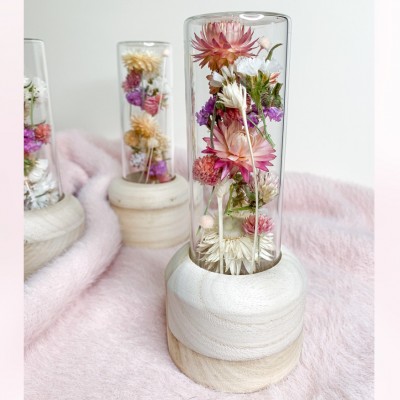 Tube en verre contenant un mélange de fleurs séchées. Format moyen.