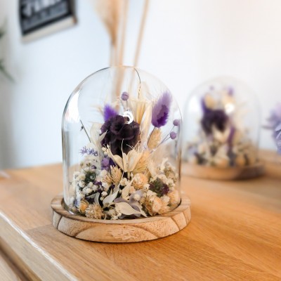 Cloche en verre et base en bois contenant des fleurs séchées crème, parme et violet. Petit format. Collection Milka