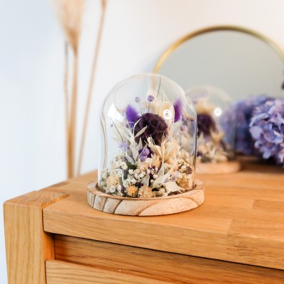 Cloche en verre et base en bois contenant des fleurs séchées crème, parme et violet. Petit format. Collection Milka