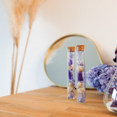 Tube en verre contenant des fleurs séchées crème, parme et violet. Petit format. Collection Milka