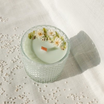 Bougie parfumée à la fleur de coton et décorée de fleurs séchées. Mèche en bois.