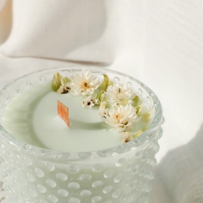 Bougie parfumée à la fleur de coton et décorée de fleurs séchées. Mèche en bois.