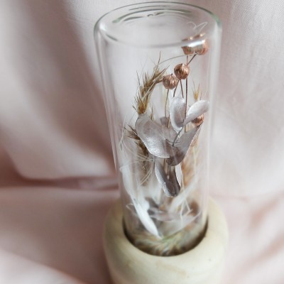 Tube en verre contenant des fleurs séchées crème, champagne et cuivre. Format moyen.