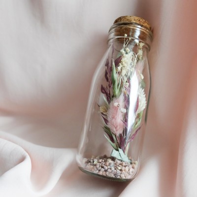 Fiole en verre contenant des fleurs séchées crème, rose et vert. Format moyen.
