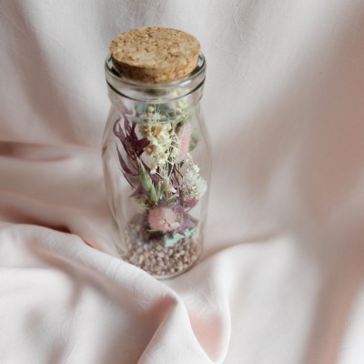 Fiole en verre contenant des fleurs séchées crème, rose et vert. Format moyen.