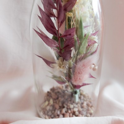 Fiole en verre contenant des fleurs séchées crème, rose et vert. Format moyen.