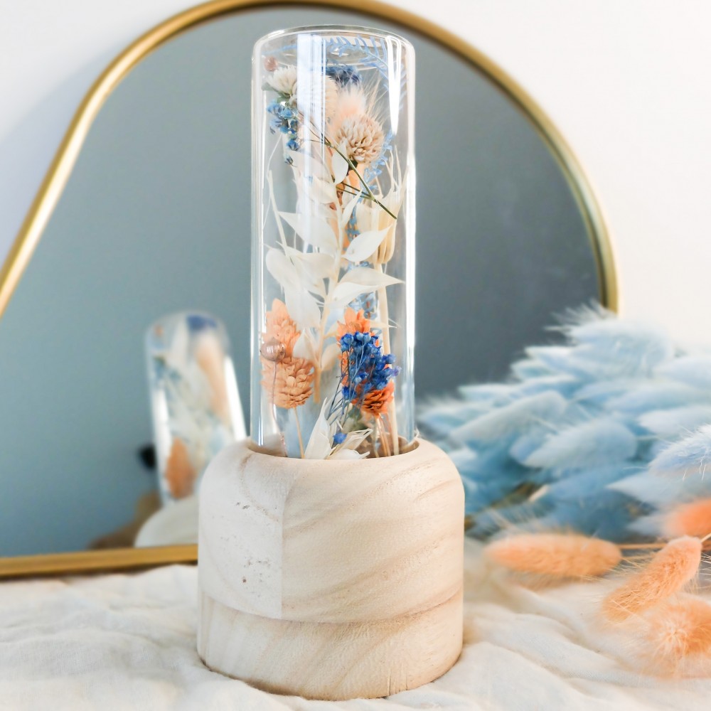 Tube en verre contenant des fleurs séchées blanches, pêche et bleu ciel. Format moyen. Collection Pêche Bleue