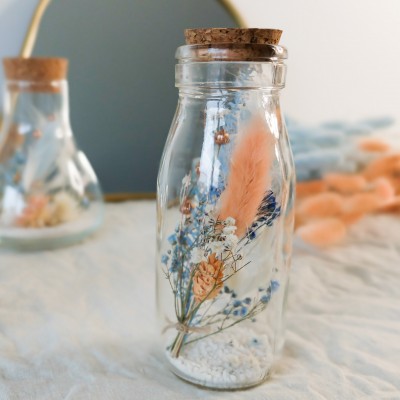 Fiole en verre contenant des fleurs séchées blanches, pêche et bleu ciel. Format moyen. Collection Pêche Bleue